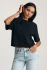 Close-up detail view of the soft black cotton knit fabric texture and crew neck ribbing