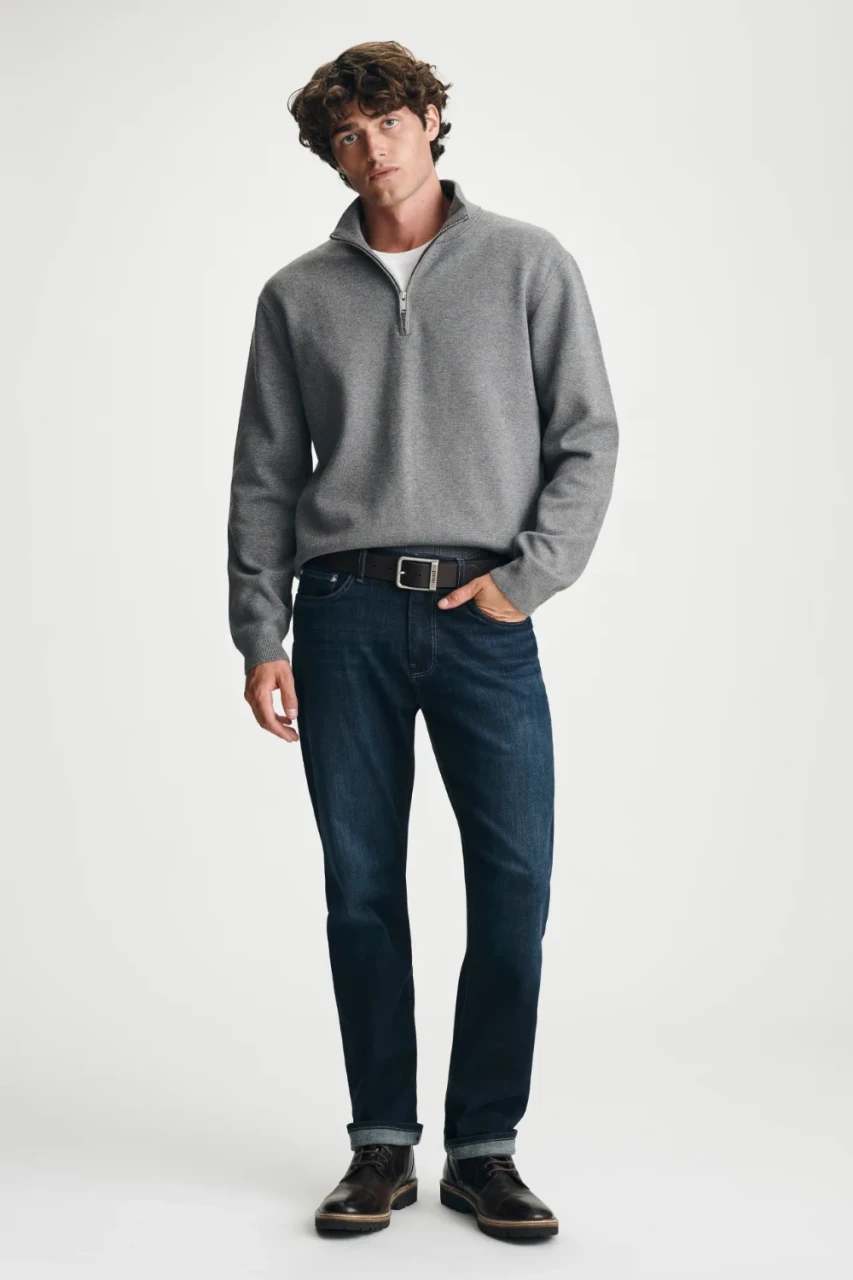 Full-length portrait of model wearing grey melange Mavi quarter-zip sweater styled casually with denim