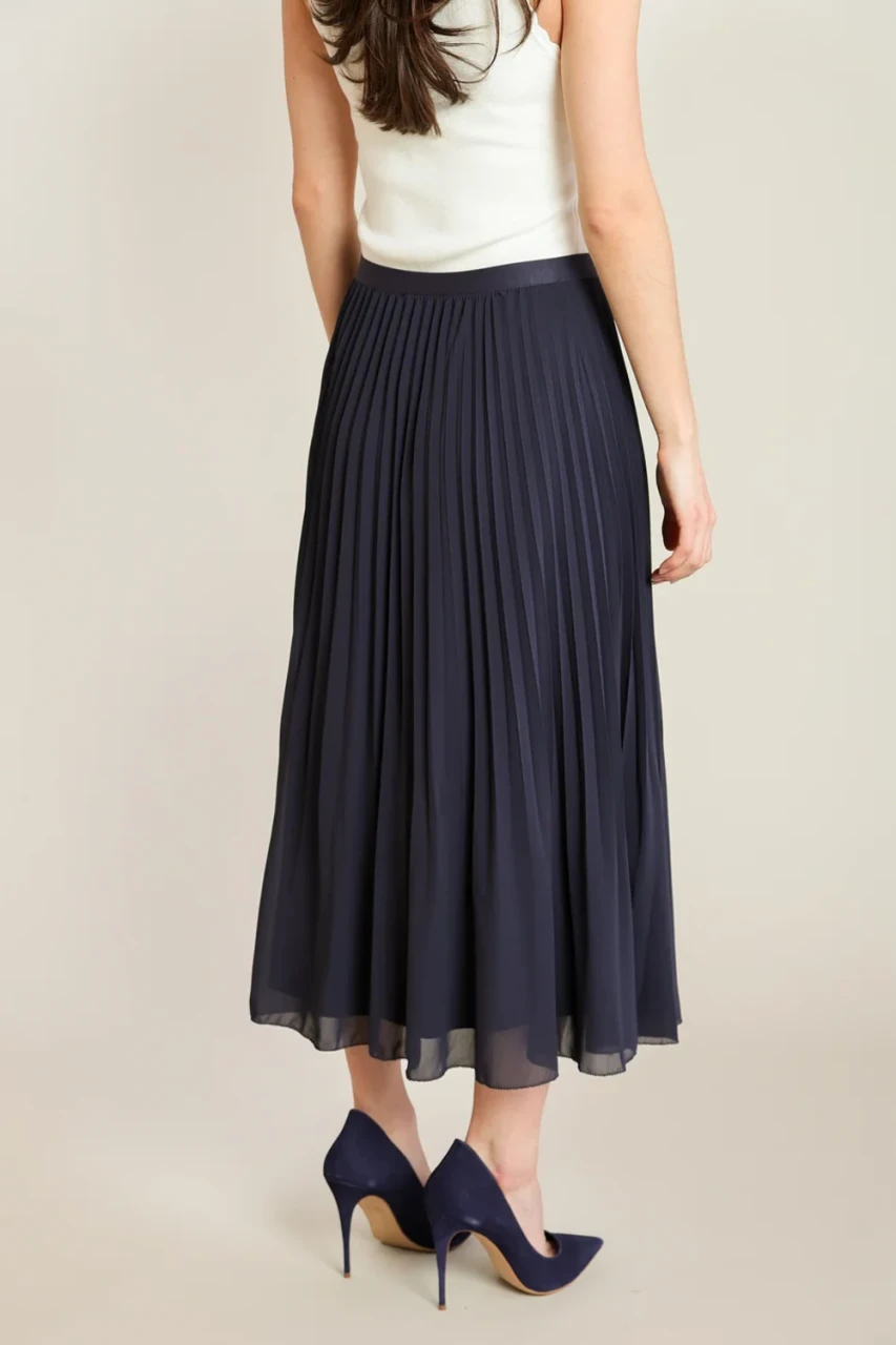 Back view of Black Tape navy pleated midi skirt showing fluid movement and midi drape