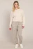 Full-length portrait of model wearing Room 34 oatmeal cuffed hem pants styled with top