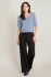 Full-length portrait of model wearing Black Tape steel puffy sleeve sweater top styled with denim