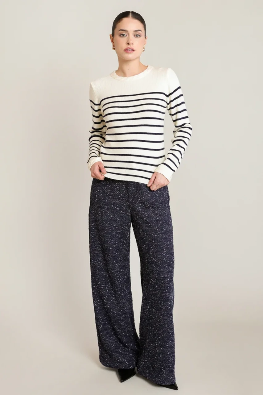 Full-length portrait of model wearing Black Tape navy stripe sweater top styled with denim
