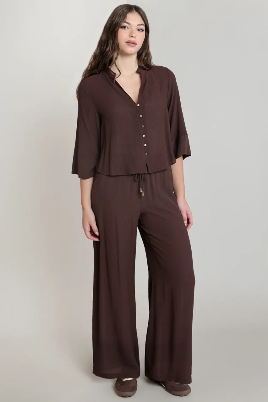 Full-length portrait of model wearing Dex dark chocolate flowy wide-leg pants styled with a top