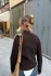 Full-length portrait view of a person walking down the street with their hair in a French twist secured by a tortoiseshell French pin