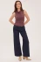 Full-length portrait of model wearing mulberry purple Gentle Fawn Indra tank styled with denim