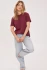 Full-length portrait of model wearing fig plum Gentle Fawn Victoria t-shirt styled with denim