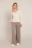 Full-length portrait of model wearing Room 34 cream heather Romy ribbed sweater top styled with trousers