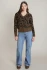 Full-length portrait of model wearing Dex brown/black leopard v-neck sweater styled with denim
