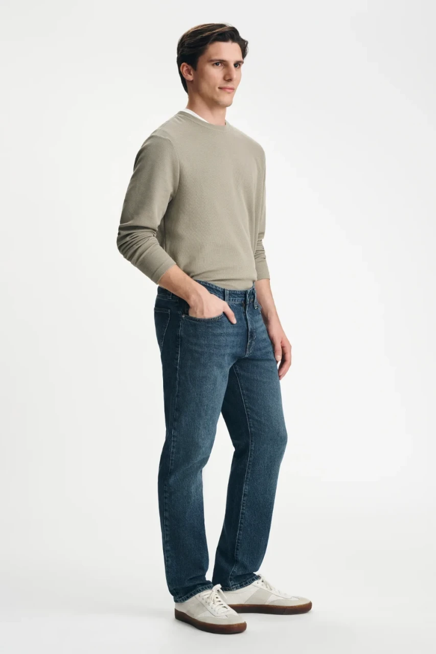 Side view of model wearing Mavi Zach dark brushed jeans highlighting the straight leg fit and clean hem