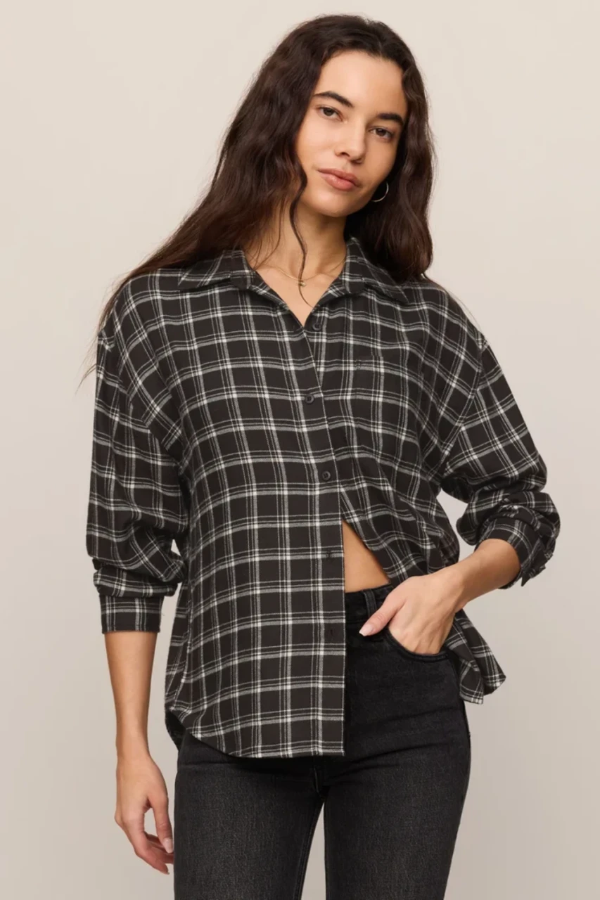 Model wearing ash black Z Supply plaid shirt highlighting the curved hemline and relaxed drape