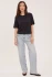 Full-length portrait of model wearing black Gentle Fawn Codie T-shirt styled with denim