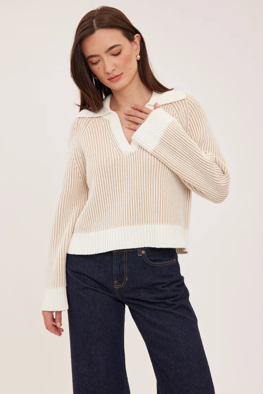 Portrait of model wearing cream Gentle Fawn Xander collared sweater styled with high-waisted trousers