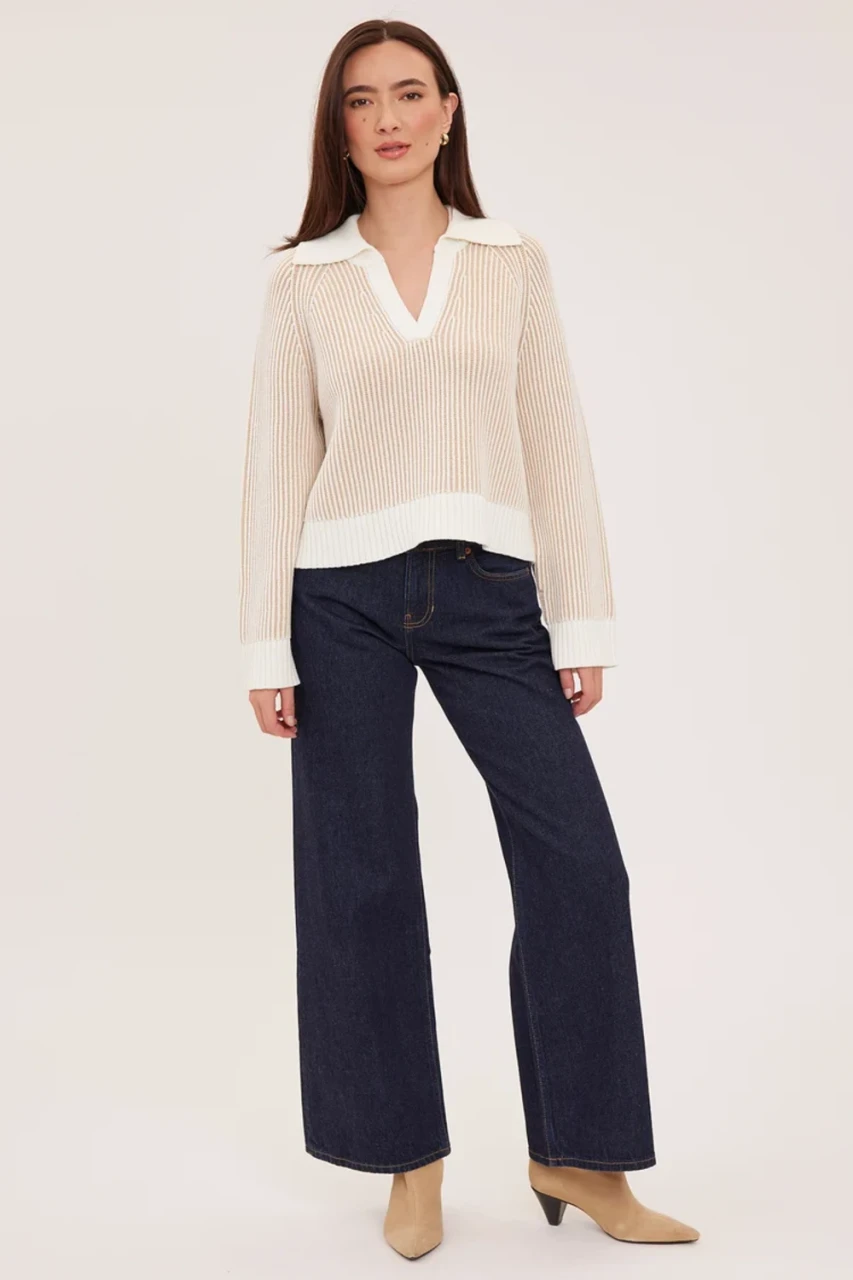 Full-length portrait of model wearing cream Gentle Fawn Xander collared sweater styled with high-waisted trousers
