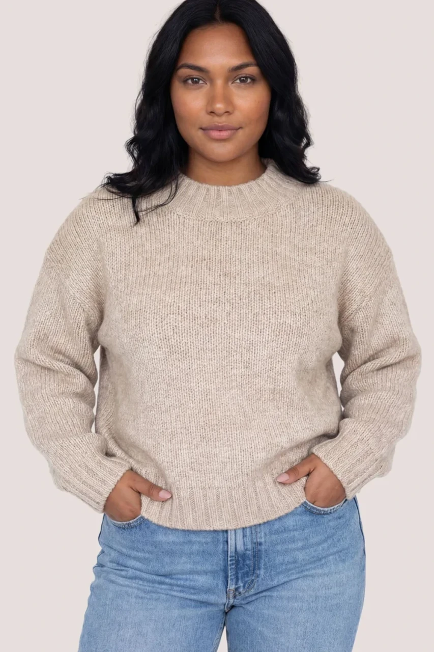 Front view of Gentle Fawn Tova sweater in heather pebble showing oversized crew neckline and heathered knit with hands in pocket