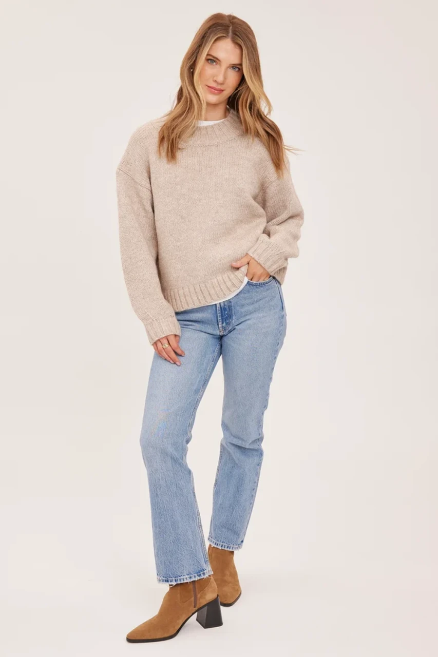 Full-length portrait of model wearing heather pebble grey Gentle Fawn Tova sweater styled with high-waisted jeans