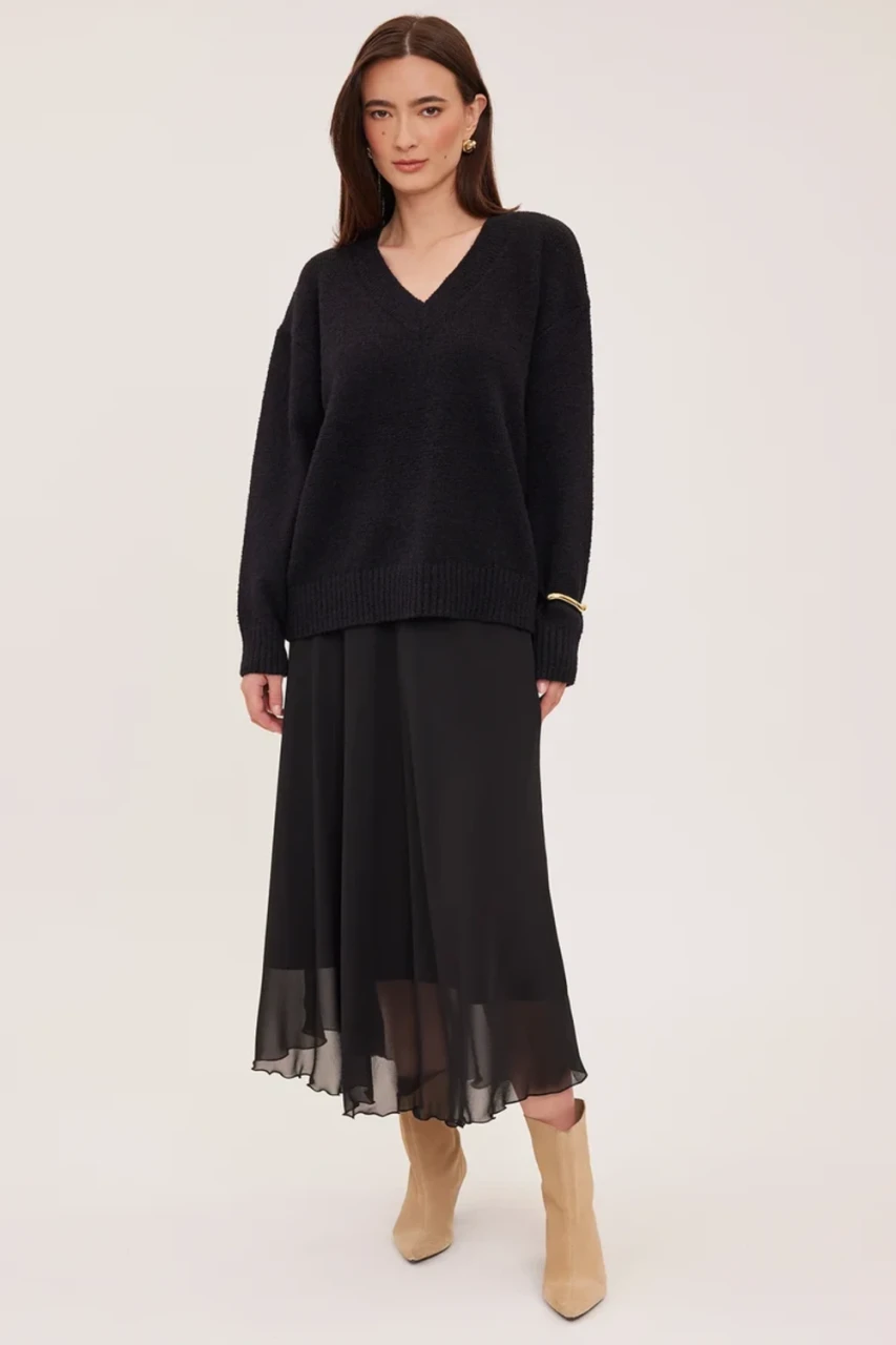 Full-length portrait of model wearing black Gentle Fawn Arianna chiffon midi skirt styled with a cozy sweater
