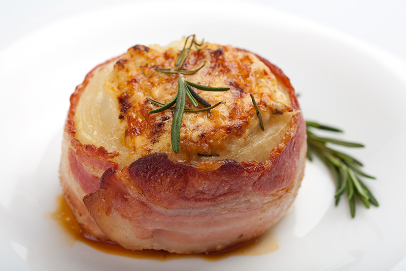 Onions stuffed with beef and cheese wrapped in bacon
