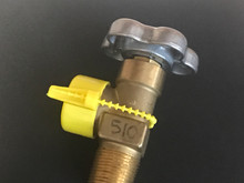 This cap has a strap that wraps around the valve.  The strap must be broken to remove the cap.