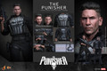 The Hot Toys MMS904 standard dynamic pose shows Jon Bernthal as The Punisher standing complete in his weathered skull tactical vest holding a heavy assault rifle.