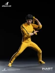 The front view displays the InArt Bruce Lee 1/12 figure standing in a classic martial arts stance wearing his iconic yellow jumpsuit.