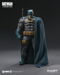 A close up photograph highlights the intricate details of the grinning head sculpt and the battle damaged chest emblem on the Batman figure.