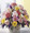 This cheery basket is a welcome sight. Bright and fluffy pink carnations, lavender and yellow daisy pompoms, with white and purple accents are arranged in a handled basket. Its the perfect gift for any occasion.
