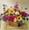 This brightly colored bouquet arrives in a basket and will fill any room with color. Arrangement includes peach spray roses, hot pink ranunculus, orange mini gerbera daisies, purple Stock and more.