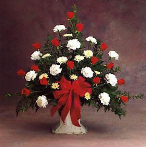 This bouquet expresses deep feelings beautifully with red and white flowers, lush greenery and a large bow. Appropriate for a funeral.