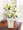 This striking display of pure white lilies will send your heartfelt expressions when words just aren't enough. Arranged in a white ceramic vase and enhanced by a silvertone cross, this arrangement is perfect for First Communion celebrations, confirmations, Sympathy, Weddings, or a religiousl Anniversary.