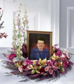 Small roses, hot pink mini Gerbera daisies, pink larkspur and heather are combined in this beautiful wreath. This design of pink blooms is intended to embrace a photo of your Loved one during a memorial service.