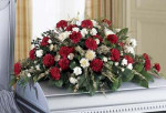 Your sincere wishes of Sympathy are conveyed using red and white blooms against a lush background of greens in this casket spray.