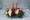 Two red tapers to light your Christmas family dinner, or your best friend's party table. Seasonal pine, fir, red blueberry branches, cones, roses, ribbons, and mixd mums.