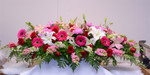 A stunning display of pink snapdragons, roses hot pink gerbera, red freedom roses and white oriental liles. this is a spray for a closed casket. Made exclusively in our flower shop. toronto and GTA area deliveries.