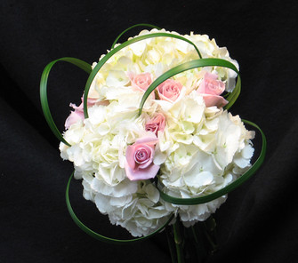 Bride's bouquet made with white Hydrangea, pink Esther roses and lily grass for accent. This is a hand tied bouquet that is so popular. The bridal party will look smashing with this bouquet. We have been delivering bridal flowers for ove 100 years in Toronto and area.