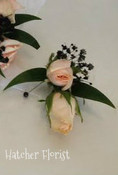 Soft flamingo pink boutonniere with ruscus, sweetheart roses and  black baby breath. Made to match the wristlet.
