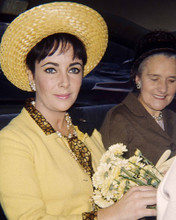 ELIZABETH TAYLOR YELLOW OUTFIT AND HAT HOLDING FLOWERS PRINTS AND POSTERS 284839