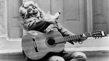 Dolly Parton 1970's in denim out fit with guitar sitting on porch 5x7 photo