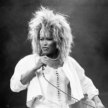 Tina Turner in full throttle on stage performing in white outfit 12x12 photo