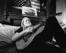 Willie Nelson lying on bed with guitar under American flag 12x18  Poster