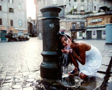 Laura Gemser takes a drink from a street water fountain 8x10 photo