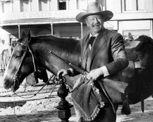 John Wayne tethers his horse whilst carrying rifle & cushion The Shootist 8x10