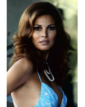 Raquel Welch in blue dress and pearls circa 1972 looks to side 8x10 inch photo