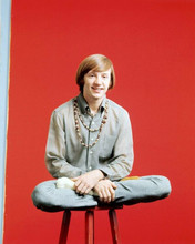 The Monkees Peter Tork wears beads around neck sitting on stool 8x10 inch photo