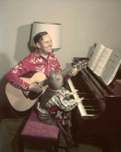 Gene Autry plays guitar sitting with young son at piano 8x10 inch photo