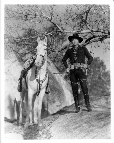 William Boyd hand on gun standing with horse Topper Hopalong Cassidy ...