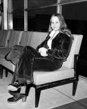 Linda Blair circa 1975 full length pose sits in airport lounge 8x10 inch photo