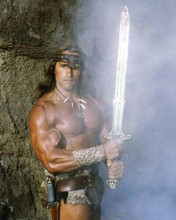 Arnold Schwarzenegger holds the gleaming sword as Conan The Barbarian 8x10 photo