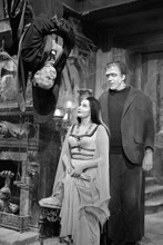 The Munsters Grandpa upside down greeting Herman & Lily in hallway 12x18 Poster