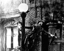 Singin' in The Rain classic Gene swinging from lamp post in rain 8x10 inch photo
