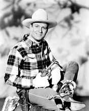 Gene Autry sits on his saddle with gun drawn 8x10 inch photo